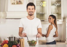 Der junge Mann und seine Frau bereiten Abendessen in der Küche vor stockbild Der junge Mann und seine Frau bereiten Abendessen in der Küche vor stockbild