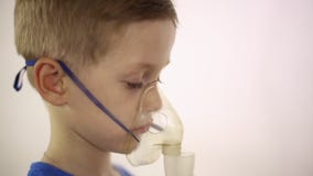 Der Junge in der Maske der Inhalator wird behandelt stock video footage Der Junge in der Maske der Inhalator wird behandelt stock video footage