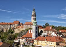 Der Kirchturm des St. Vitus Church in Cesky Krumlov, mit dem Ceskly-Schloss-Turm im Hintergrund lizenzfreies stockbild Der Kirchturm des St. Vitus Church in Cesky Krumlov, mit dem Ceskly-Schloss-Turm im Hintergrund lizenzfreies stockbild