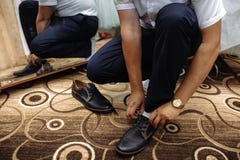 Der Mann bindet oben seinen Schuh auf einem Teppich stockfotos Der Mann bindet oben seinen Schuh auf einem Teppich stockfotos