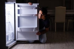 Der Mann, der Di?t nachts nahe K?hlschrank bricht lizenzfreies stockbild Der Mann, der Di?t nachts nahe K?hlschrank bricht lizenzfreies stockbild