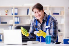 Der männliche Reiniger, der im Büro arbeitet lizenzfreie stockfotografie Der männliche Reiniger, der im Büro arbeitet lizenzfreie stockfotografie