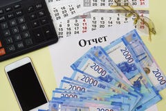 Der Titel im russische Sprachenbericht über eine Leerseite, Taschenrechner, Smartphone, Sonnenbrille und neue russische Banknoten lizenzfreie stockfotos Der Titel im russische Sprachenbericht über eine Leerseite, Taschenrechner, Smartphone, Sonnenbrille und neue russische Banknoten lizenzfreie stockfotos