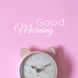 Der Wecker auf einem rosa Hintergrund und dem guten Morgen des Textes vektor abbildung Der Wecker auf einem rosa Hintergrund und dem guten Morgen des Textes vektor abbildung