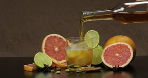 Derrame o u?sque, conhaque, licor de uma garrafa em um copo de vidro imagem de stock Derrame o u?sque, conhaque, licor de uma garrafa em um copo de vidro imagem de stock