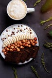 Desayuno sano con pan delicioso, el plátano, la avellana, el yogur en cuenco y una taza de café, de latte o de cacao con leche en imagenes de archivo Desayuno sano con pan delicioso, el plátano, la avellana, el yogur en cuenco y una taza de café, de latte o de cacao con leche en imagenes de archivo