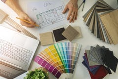designer working in office doing furniture and flooring material selection from samples for home interior design project