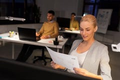 Designer working with papers at night office stock photos Designer working with papers at night office stock photos