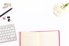 Desk in office with keyboard, pencil, colored paper clips, chrysanthemum flower and open the pink diary on a white background. Bu stock images Desk in office with keyboard, pencil, colored paper clips, chrysanthemum flower and open the pink diary on a white background. Bu stock images