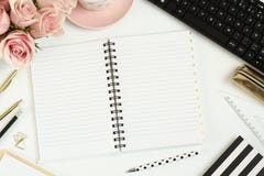 Desk with pink flowers, empty notebook and computer Stock Photos Desk with pink flowers, empty notebook and computer Stock Photos