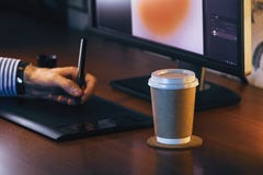 Desktop with computer, graphics tablet and a cup of coffee. Side view stock photo Desktop with computer, graphics tablet and a cup of coffee. Side view stock photo