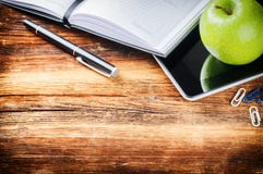 Desktop with paper agenda, digital tablet and green apple royalty free stock images Desktop with paper agenda, digital tablet and green apple royalty free stock images