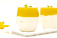 Dessert de fruit avec la mangue et la menthe au-dessus du fond blanc Mousse de mangue Dessert italien image stock Dessert de fruit avec la mangue et la menthe au-dessus du fond blanc Mousse de mangue Dessert italien image stock