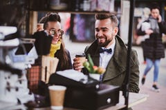 Det attraktiva smarta paret tycker om kaffe, medan sitta utanf?r p? den lilla coffeeshoen royaltyfri fotografi Det attraktiva smarta paret tycker om kaffe, medan sitta utanf?r p? den lilla coffeeshoen royaltyfri fotografi