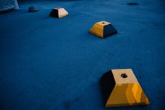 Det konkreta kvarteret av den avkortade gula pyramiden mot bakgrunden av bl? asfalt fotografering för bildbyråer Det konkreta kvarteret av den avkortade gula pyramiden mot bakgrunden av bl? asfalt fotografering för bildbyråer