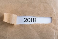 Det nya året 2018 är det kommande begreppet Meddelande 2018 för lyckligt nytt år som visas bak rivit sönder brunt papper royaltyfri foto Det nya året 2018 är det kommande begreppet Meddelande 2018 för lyckligt nytt år som visas bak rivit sönder brunt papper royaltyfri foto