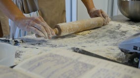 Detail of woman`s hand rolling out a dough with a rolling pin while making homemade pasta. Woman`s hands rolling dough stock photography Detail of woman`s hand rolling out a dough with a rolling pin while making homemade pasta. Woman`s hands rolling dough stock photography