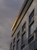 detalj av grå kontorsbyggnad med stora fönster i guld- evenin royaltyfria foton detalj av grå kontorsbyggnad med stora fönster i guld- evenin royaltyfria foton