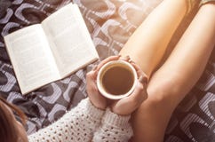 Detaljen av den sexiga unga kvinnan och solen tänder Kvinnauppehälle per kaffekoppen och läst en bok arkivfoto Detaljen av den sexiga unga kvinnan och solen tänder Kvinnauppehälle per kaffekoppen och läst en bok arkivfoto