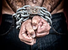 Detalle de las manos encadenadas de un hombre Detalle de las manos encadenadas de un hombre