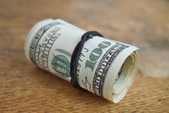 Detalle macro de un rollo verde de la moneda americana USD, dólares americanos con 100 dólares de billete de banco en el exterior imagenes de archivo Detalle macro de un rollo verde de la moneda americana USD, dólares americanos con 100 dólares de billete de banco en el exterior imagenes de archivo