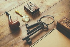 Detective concept. Private Detective tools: magnifier glass, old keys, smoking pipe, notebook. top view. vintage filtered image Royalty Free Stock Photo Detective concept. Private Detective tools: magnifier glass, old keys, smoking pipe, notebook. top view. vintage filtered image Royalty Free Stock Photo