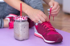 Detox Smoothie In Retro Jar And Young Woman Lacing Sport Footwear Royalty Free Stock Images