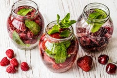 Detox woda z malinką, truskawka, wiśnia na białym drewnianym tle pije zdrowego fotografia royalty free Detox woda z malinką, truskawka, wiśnia na białym drewnianym tle pije zdrowego fotografia royalty free