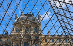 Dettagli classici della facciata del Louvre Parigi Francia attraverso il vetro della piramide immagine stock Dettagli classici della facciata del Louvre Parigi Francia attraverso il vetro della piramide immagine stock