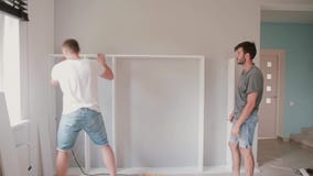 Deux amis assemblant l'étagère, font les réparations Équipez l'aide à son ami se déplaçant à la nouvelle maison clips vidéos Deux amis assemblant l'étagère, font les réparations Équipez l'aide à son ami se déplaçant à la nouvelle maison clips vidéos
