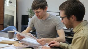 Deux architectes semblant le plan intérieur et parlant se reposer dans le bureau à l'intérieur banque de vidéos Deux architectes semblant le plan intérieur et parlant se reposer dans le bureau à l'intérieur banque de vidéos