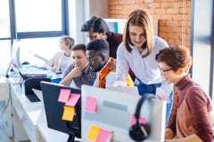 Deux assistants aidant de nouveaux employeers fonctionnant avec l'ordinateur et l'ordinateur portable images stock Deux assistants aidant de nouveaux employeers fonctionnant avec l'ordinateur et l'ordinateur portable images stock