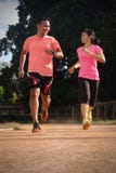 Deux associ?s de sports pulsent ensemble un jour ensoleill? utilisant les chemises oranges et roses Ils regardent l'un l'autre et images stock Deux associ?s de sports pulsent ensemble un jour ensoleill? utilisant les chemises oranges et roses Ils regardent l'un l'autre et images stock