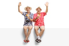 Deux aînés de cheerfull tenant des cocktails et l'ondulation image libre de droits Deux aînés de cheerfull tenant des cocktails et l'ondulation image libre de droits