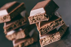 Deux bâtiments de chocolat sur un fond foncé énergie et sucre Barre cassée Pile de blocs de chocolat Photo stock Deux bâtiments de chocolat sur un fond foncé énergie et sucre Barre cassée Pile de blocs de chocolat Photo stock