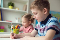 Deux enfants mignons dessinant avec les crayons colorés Image libre de droits Deux enfants mignons dessinant avec les crayons colorés Image libre de droits