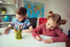 Deux enfants mignons dessinant avec les crayons colorés Images stock Deux enfants mignons dessinant avec les crayons colorés Images stock