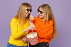 Deux filles blondes assez jeunes de soeurs de jumeaux en verres de l'imax 3d observant la pellicule cinématographique, tenant le photo stock Deux filles blondes assez jeunes de soeurs de jumeaux en verres de l'imax 3d observant la pellicule cinématographique, tenant le photo stock