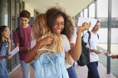Deux filles célébrant des résultats d'examen dans le couloir d'école images libres de droits Deux filles célébrant des résultats d'examen dans le couloir d'école images libres de droits