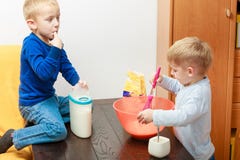 Deux garçons cuisson d'enfant, faisant le gâteau dans la cuvette Photographie stock libre de droits Deux garçons cuisson d'enfant, faisant le gâteau dans la cuvette Photographie stock libre de droits