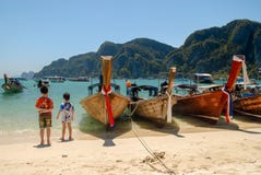 Deux garçons sur la plage avec des bateaux de longue queue photos libres de droits Deux garçons sur la plage avec des bateaux de longue queue photos libres de droits