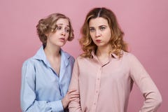 Deux jeunes amis réconcilient Le concept des excuses et du ressentiment la fille dans la chemise bleue demande la rémission de l' image libre de droits Deux jeunes amis réconcilient Le concept des excuses et du ressentiment la fille dans la chemise bleue demande la rémission de l' image libre de droits