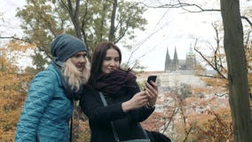 Deux jolis et jeune femme heureuse faisant Selife avec le téléphone portable en Autumn Park Les meilleurs amis font le selfie photographie stock libre de droits Deux jolis et jeune femme heureuse faisant Selife avec le téléphone portable en Autumn Park Les meilleurs amis font le selfie photographie stock libre de droits