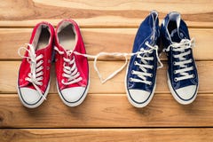 Deux paires d'espadrilles pour les hommes et les femmes - le concept de l'amour images stock Deux paires d'espadrilles pour les hommes et les femmes - le concept de l'amour images stock