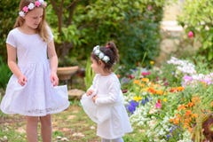 Deux petites filles dans des robes blanches ayant l'amusement un jardin d'?t? image libre de droits Deux petites filles dans des robes blanches ayant l'amusement un jardin d'?t? image libre de droits