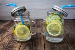 Deux pots avec une boisson avec des tranches de concombre et de citron image libre de droits Deux pots avec une boisson avec des tranches de concombre et de citron image libre de droits