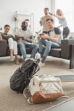 deux sacs à dos et longboard sur le premier plan et le groupe d'amis multi-ethniques avec le jeu de manettes photos stock deux sacs à dos et longboard sur le premier plan et le groupe d'amis multi-ethniques avec le jeu de manettes photos stock
