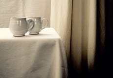 Deux tasses de thé blanches sur une table blanche sur un fond blanc photo libre de droits Deux tasses de thé blanches sur une table blanche sur un fond blanc photo libre de droits