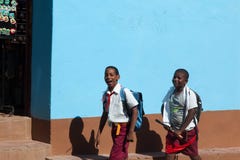 Deux écoliers marchent sur la rue de Th au Cuba en ville Trinidad Les enfants ont le lien pionnier rouge images libres de droits Deux écoliers marchent sur la rue de Th au Cuba en ville Trinidad Les enfants ont le lien pionnier rouge images libres de droits