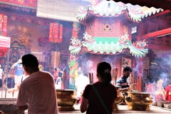 Devotos de Buddhish que ruegan en un templo chino en Kuala Lumpur foto de archivo Devotos de Buddhish que ruegan en un templo chino en Kuala Lumpur foto de archivo